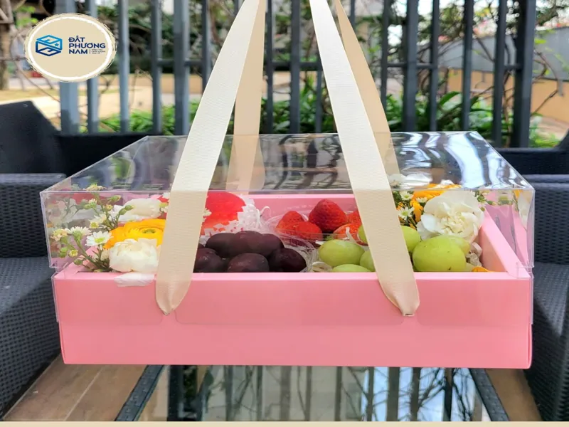 Mẫu hộp nhựa đựng bánh kem trong suốt đế giấy hồng kết hợp đựng trái cây và hoa tươi quà tặng